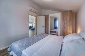 Un dormitorio con cama, armario y espejo.