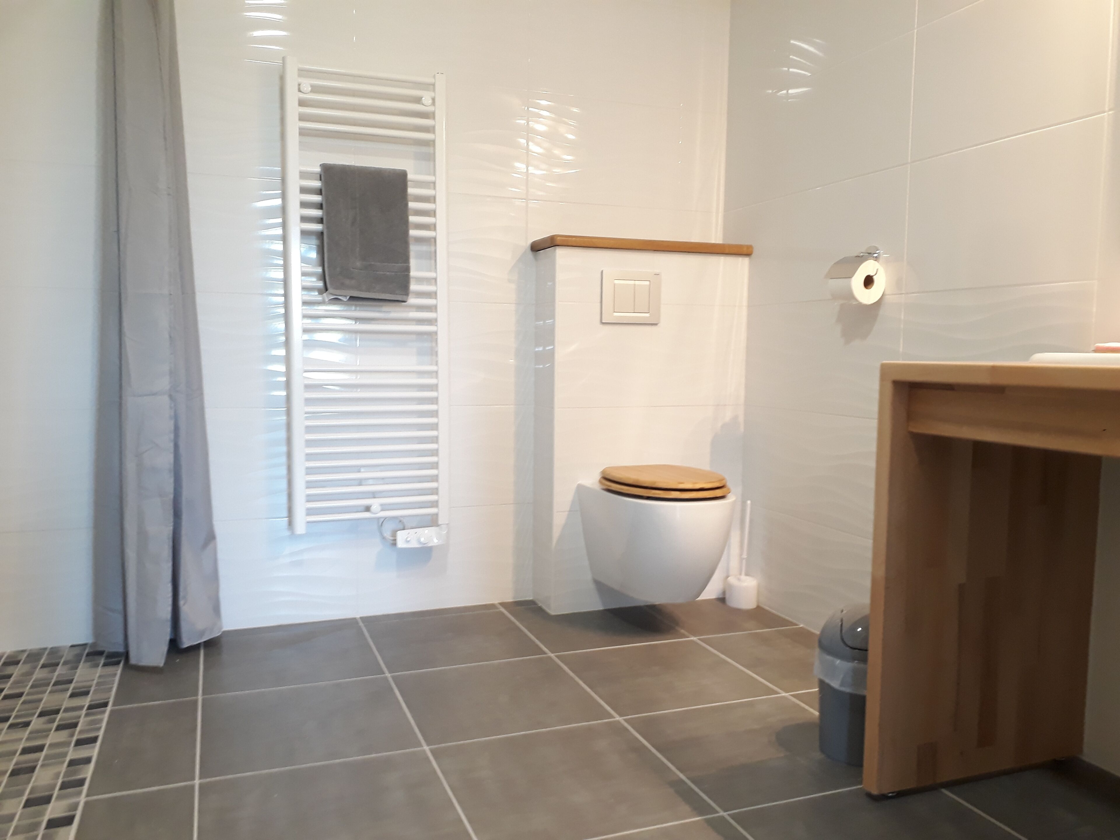 A bathroom with a toilet, a shower, and a sink.