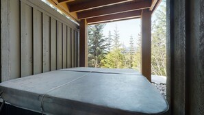 A covered outdoor seating area with a bench. - 3 Bedroom plus Den / 2.5 Bath Mountain Star Townhome, Private Hot Tub, Quiet Slope Side location (Whistler)