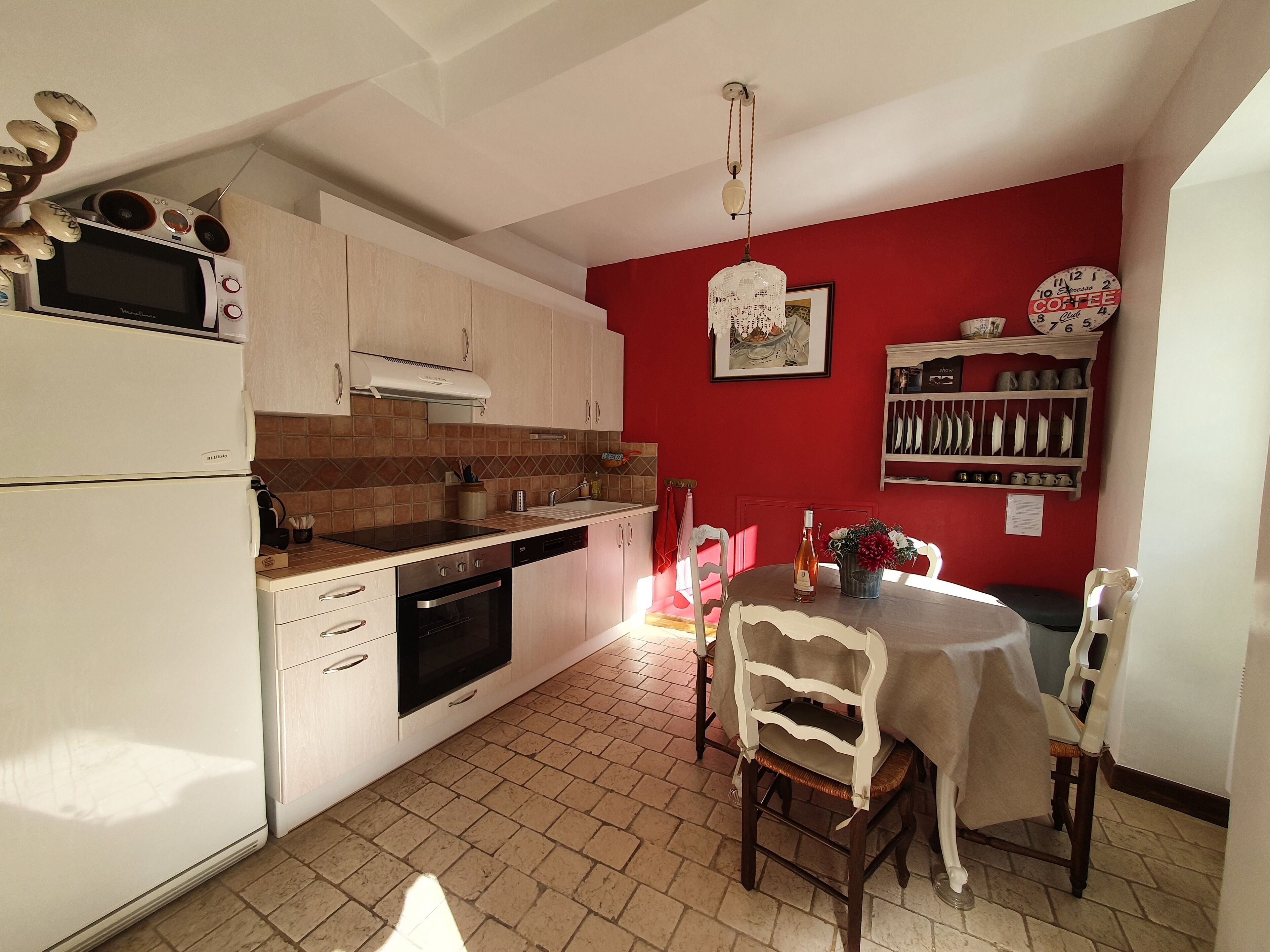 A kitchen with a dining area, equipped with a microwave, oven, and sink.