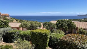 A coastal view with terracotta-roofed buildings, lush greenery, and the ocean in the background. - Magnificent House for 8–12 People in Porto Vecchio with Ocean Views of Pallombaggia and Santa Giulia (Porto-Vecchio)