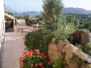A terrace with a stone staircase, outdoor seating, and a view of the sea and mountains. - Magnificent House for 8–12 People in Porto Vecchio with Ocean Views of Pallombaggia and Santa Giulia (Porto-Vecchio)