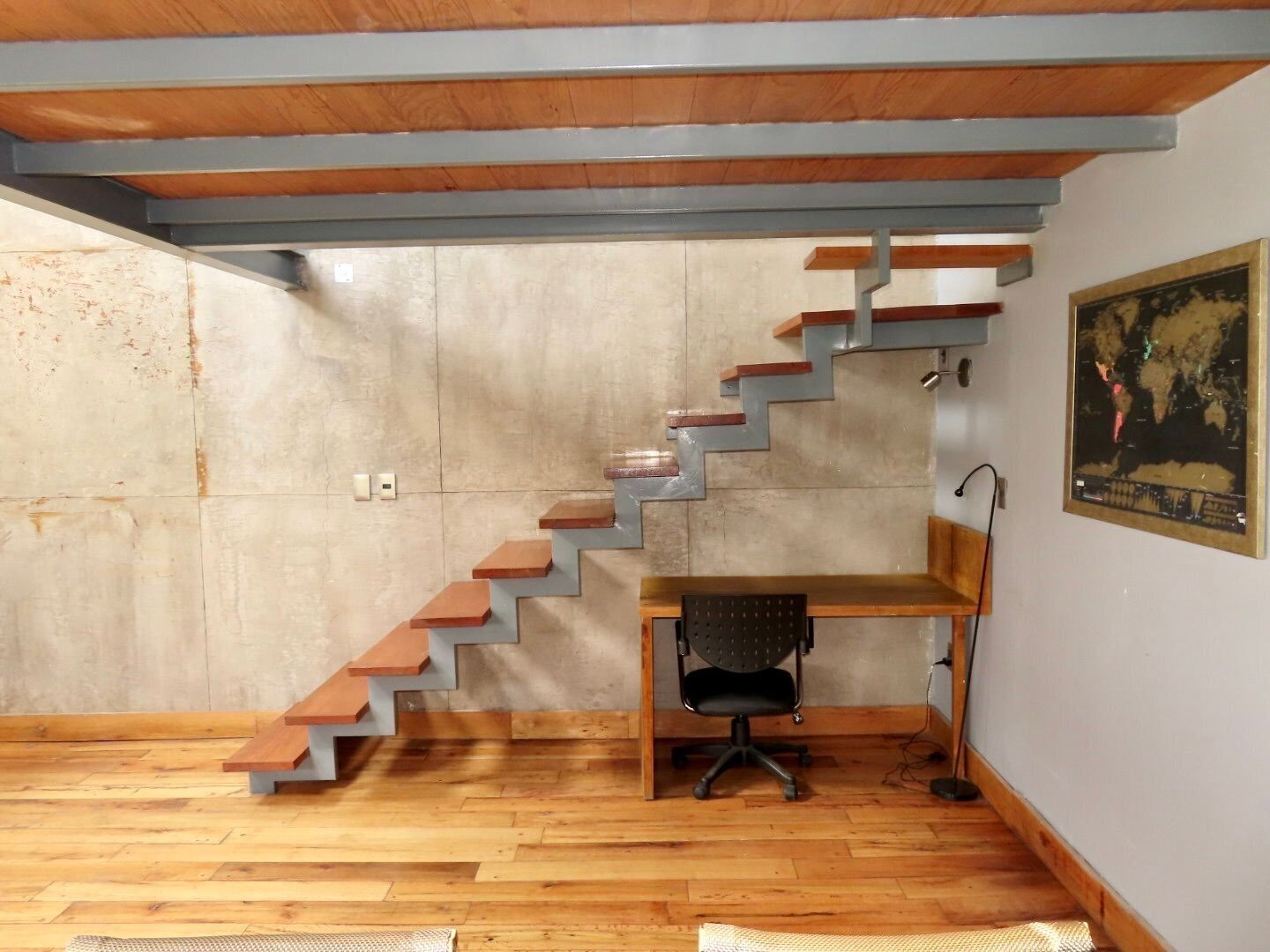 Ein modernes Zimmer mit einer Betonwand, Holzboden und einem außergewöhnlichen Treibendesign.