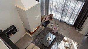 Ein modernes Wohnzimmer mit Kamin, einer Sofagarnitur, einem Couchtisch und einer dekorativen Metallskulptur.
