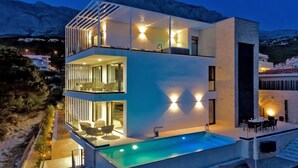 A modern two-story building with a swimming pool, balconies, and outdoor seating areas. - Villa Sea Splendor with Pool (Promajna)