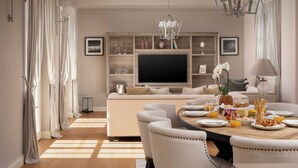 A dining area with a large table set for breakfast, a television mounted on a wooden wall, and a chandelier above. - Villa Palazzo di Claretta with Pool (Vabriga)