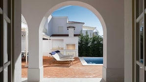 An outdoor patio with a pool, lounge chairs, and a barbecue area. - Villa Palazzo di Claretta with Pool (Vabriga)