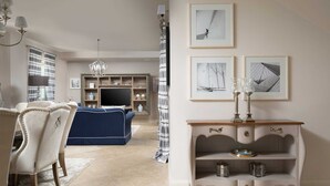 A living room with a blue sofa, a white console table with glassware, and framed artwork on the wall. - Villa Palazzo di Letizia with Pool (Vabriga)