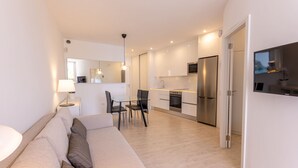 Een modern appartement met een woonkamer, eetgedeelte en keuken.