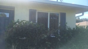 A house with a window and shutters, surrounded by dense foliage. - Golf club Villa located in beautiful Naples , 5 min from Beaches and Downtown (naples)