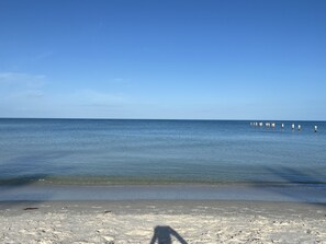 Uma praia com céu claro e mar calmo.