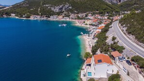 A coastal town with a beach, clear blue sea, and mountainous backdrop. - Villa Simpleza - Six Bedroom Villa with Private Pool and Jacuzzi (Klek)