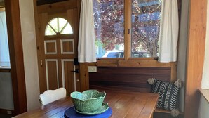 Une table de salle à manger en bois, avec un saladier vert et une nappe bleue.
