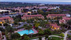 A resort with multiple buildings, a swimming pool, and lush landscaping.