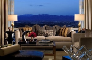Relax in this serene living room with a stunning mountain view, featuring a comfortable sofa, coffee table, and decorative vase.