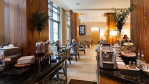 En hotellrestaurang med träpanel på väggarna, en kaffestation och en buffé.