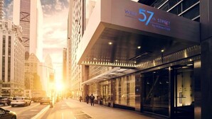 En modern hotellbyggnad med en framträdande skylt som visar adressen "West 57th Street", stora fönster och en glasfasad.
