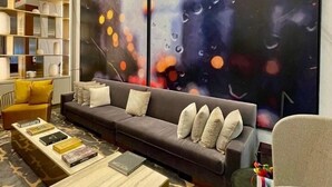 Una sala de estar moderna con un sofá modular, una mesa de centro y una estantería.
