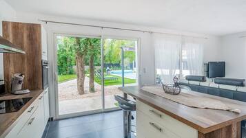 A modern kitchen with a large sliding glass door leading to a backyard.