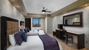 A hotel room with two beds, a desk, a chair, a TV, and a large window with a city view.