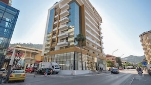 A multi-story building with a modern design, featuring balconies and large windows. - Orange Lux Apartments (Budva)