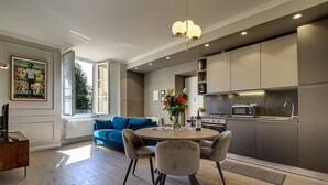 Een moderne keuken met een eethoek, met een ronde tafel, stoelen en een blauwe bank.