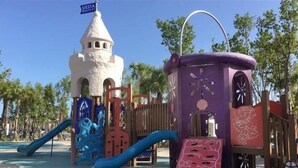 A playground with a castle-like structure, slides, and a purple playhouse. - Condo# 304 2 Bed/1 bath Condo Steps to Siesta Key Beach! (Sarasota)