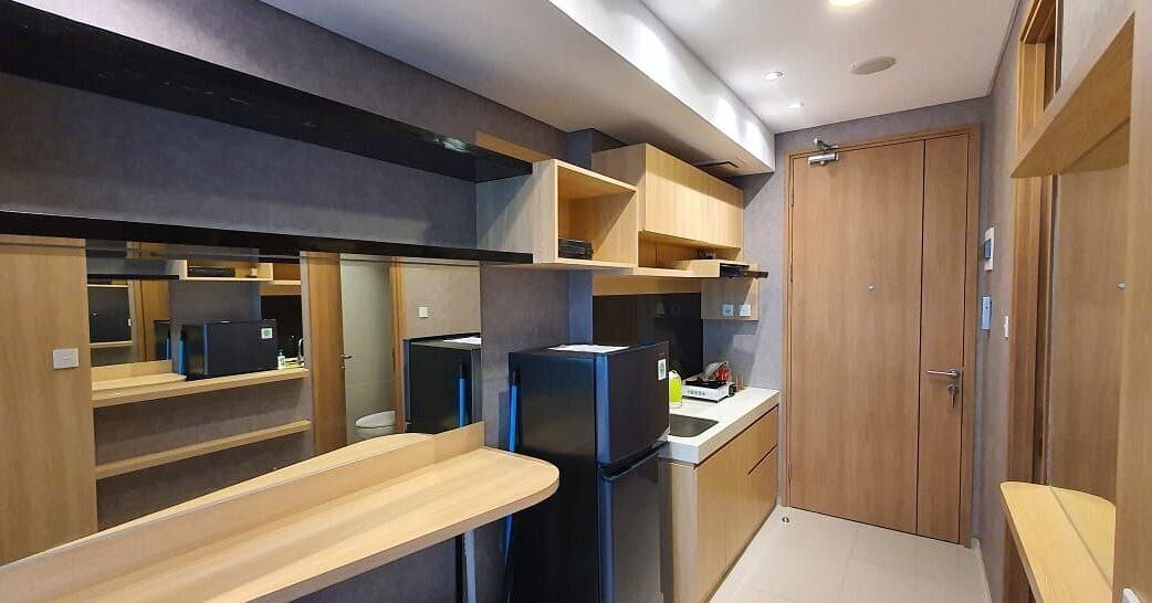 Una cocina compacta con electrodomésticos integrados, armarios de madera y una pequeña encimera.