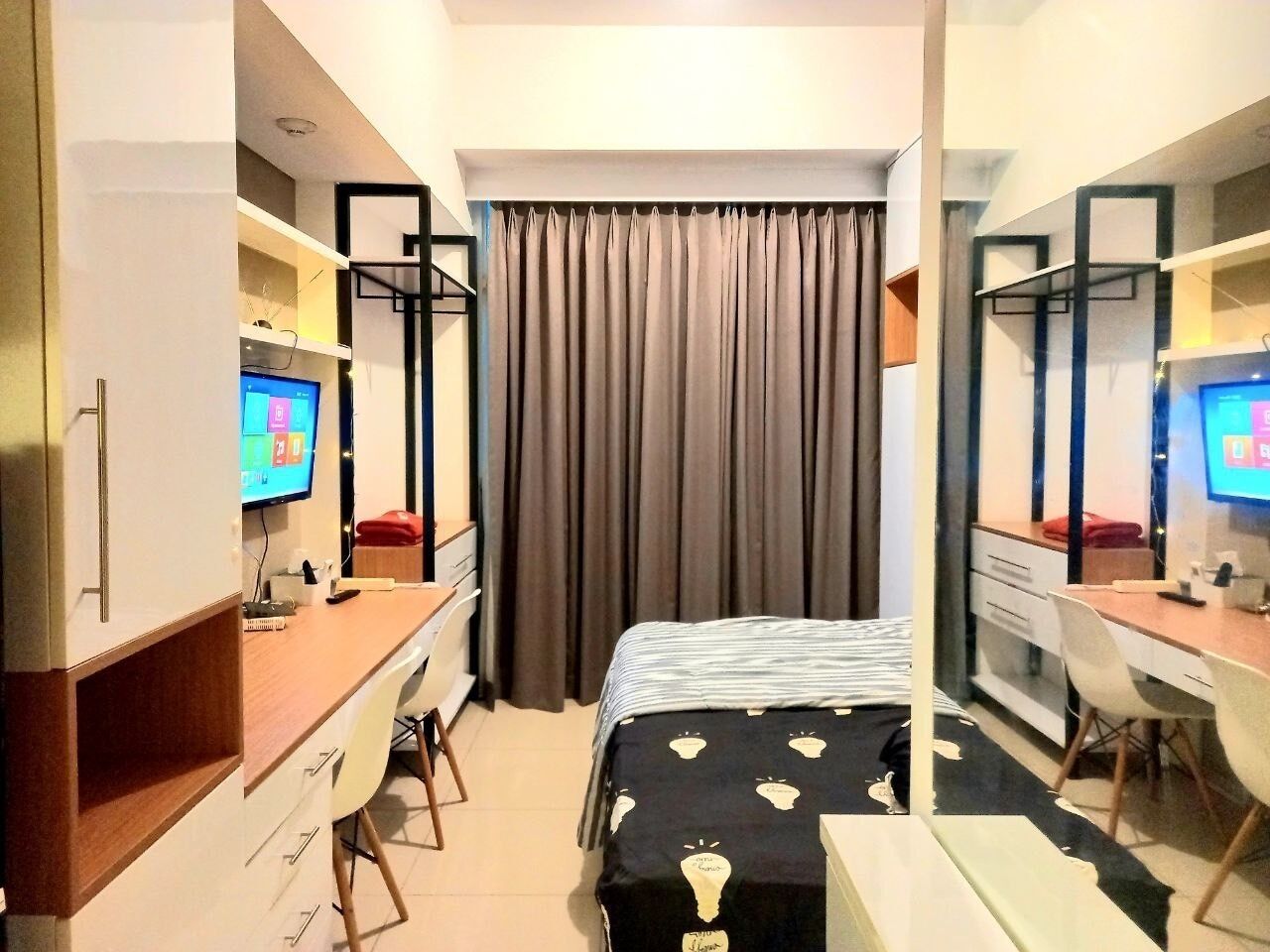Ein Hotelzimmer mit Bett, Schreibtisch, Stuhl, Fernseher und Spiegel.