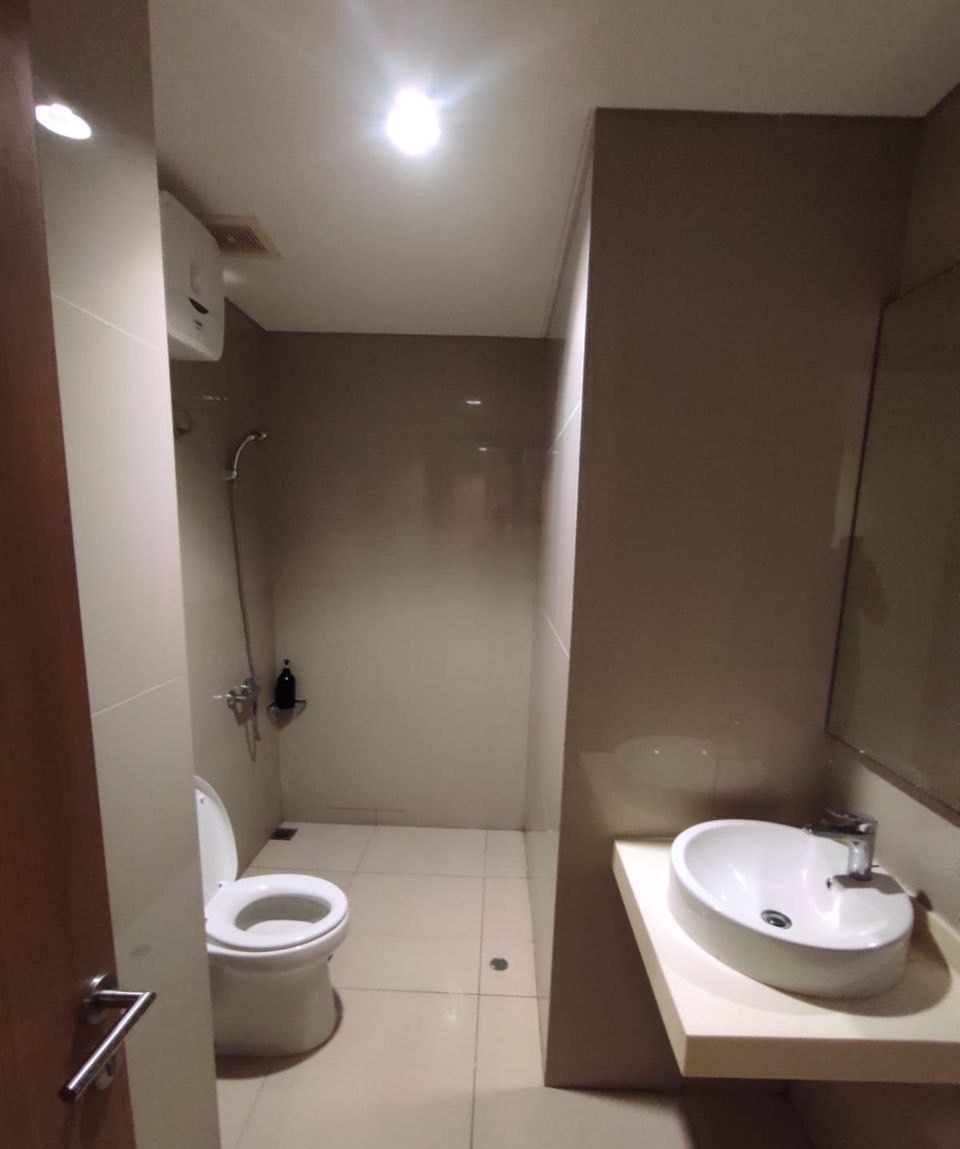 A bathroom with a toilet, a shower, and a sink.
