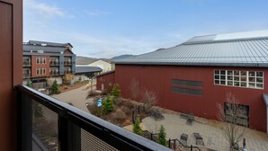 A courtyard with buildings, including a red structure with windows and a metal roof. - Amazing Unit!  Sleeps 5. Swim or Ski out your front door. On site at Silver Mt. (Kellogg)