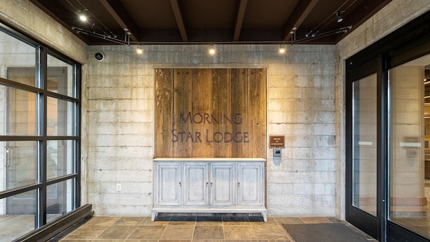 A reception area with a wooden wall, a white cabinet, and a sign that reads "Morning Star Lodge." - Amazing Unit!  Sleeps 5. Swim or Ski out your front door. On site at Silver Mt. (Kellogg)