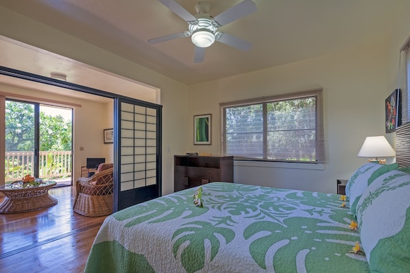 A bedroom with a bed, a ceiling fan, a window with blinds, a desk, and a chair. - Condo 500 Feet to the Ocean (Koloa)