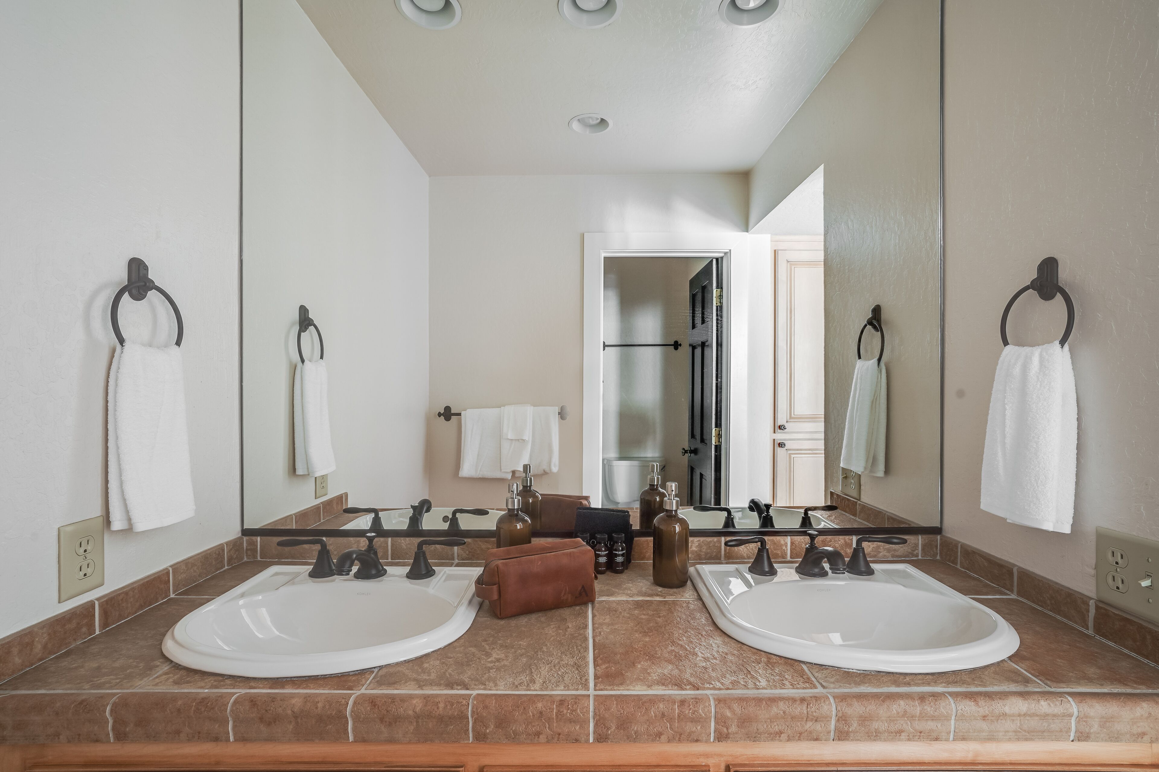 A bathroom with two sinks, a mirror, and a towel rack.