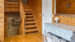 A wooden interior with a staircase, a white door, a mirror, and a small white vase on a dresser. - Tahkon rantatupa 7 b by Interhome (Nilsiä)