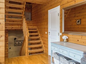 A wooden staircase leading to a loft area with a white door and a mirror on the wall. - Tahkon rantatupa 7 b by Interhome (Nilsiä)