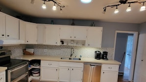 A modern kitchen with white cabinets, stainless steel appliances, and a granite countertop. - A House Where Families Laugh, Cry and Just Be!!! (Jacksonville)