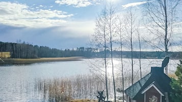 Une vue sur le lac, avec un chalet et une jetée qui s’avance dans l’eau.