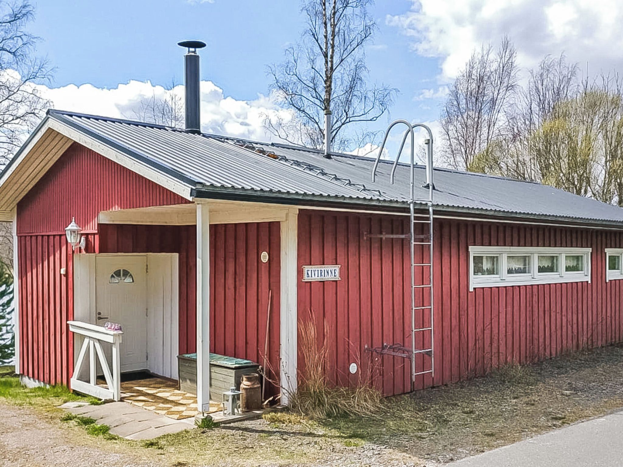 A red building with a metal roof, a door, and a window.
