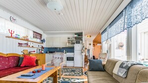 En hyggelig stue med en sofa, et træbord og en gulvtæppe med mønster.