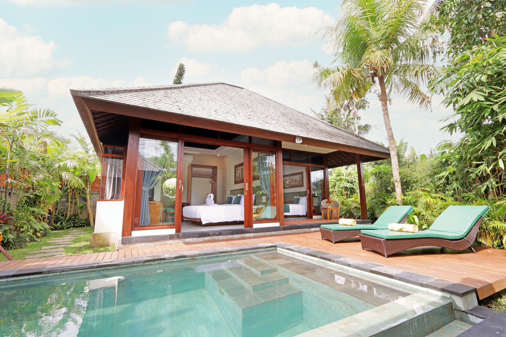 A modern villa with a pool, a bedroom, and a lounge area.