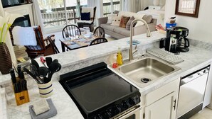 A modern kitchen with a stove, sink, and dining area. - Oz Festival! Walk to Resort! Pets! Fireplace! (Beech Mountain)