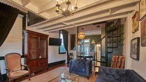 Un salon spacieux avec un grand canapé, un meuble en bois et une table basse en verre.