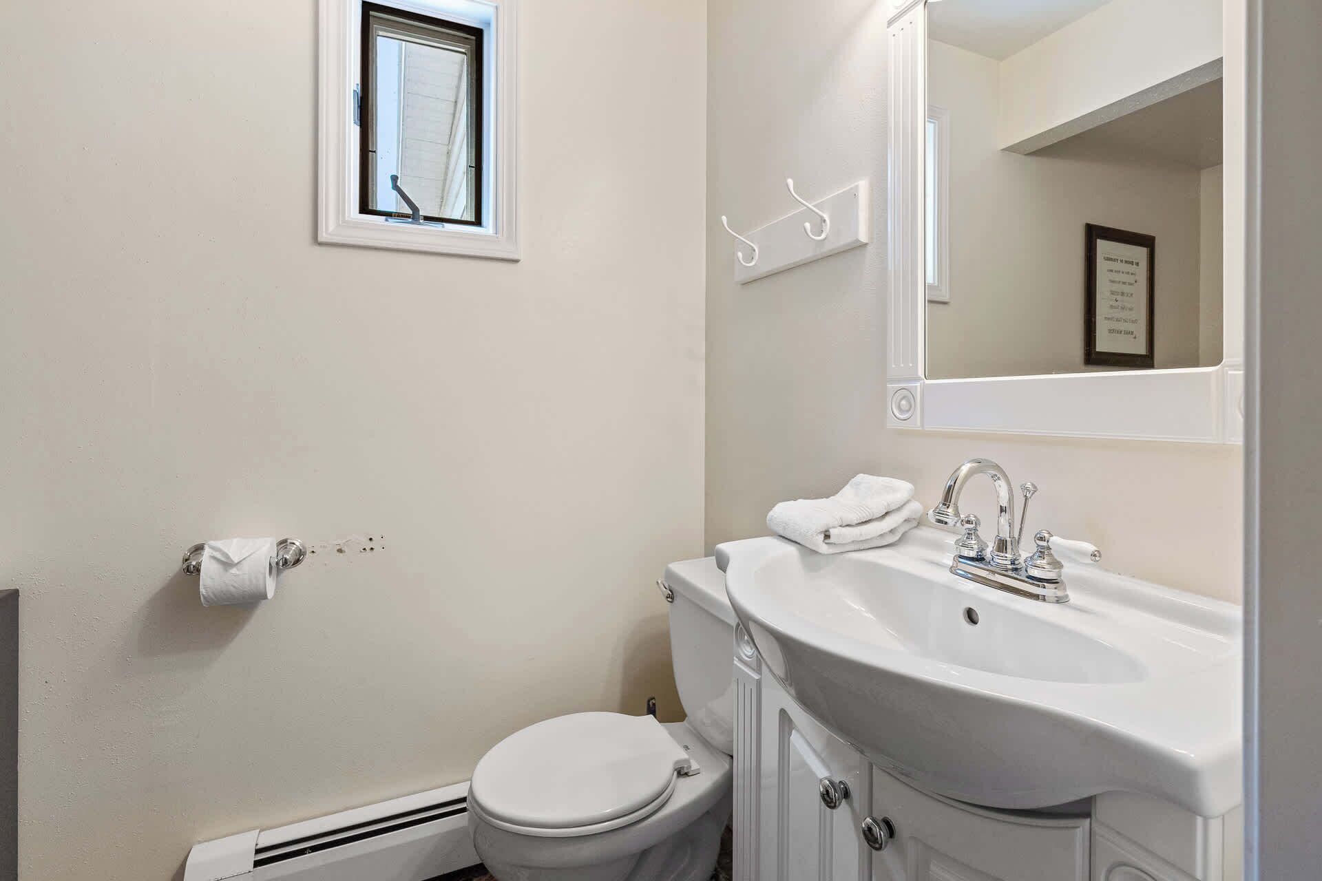 Un baño con inodoro, lavamanos y ventana.