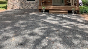 A log cabin with a stone foundation, a porch, and a door. - Hunters Home (Brule)