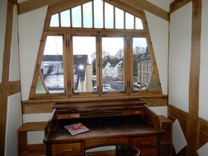 Quarto com uma janela grande de madeira que dá para a rua.