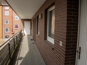A corridor with a brick wall, windows, and a door. - 077-2 Holiday apartment Jungmann - 077-2 Holiday apartment Jungmann (Wilhelmshaven)
