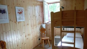A wooden room with bunk beds, a chair, and a radiator. - Maison Perchu - Pila, Vallée D'aoste (Pila)