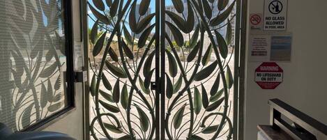A room with a metal gate, a bench, and a view of buildings outside.