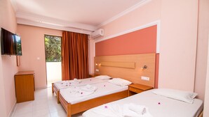 Une chambre d’hôtel avec deux lits, une télévision et un petit bureau.